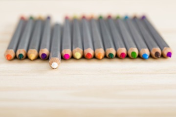 set of different colored pencils on wooden desk