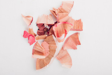 cosmetic pink pencil shavings on white background