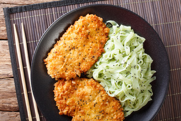 Chicken steak in breaded Panko and noodles with green tea on the table. horizontal top view
