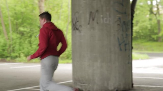 Mann in Sportkleidung springt &uuml;ber Gel&auml;nde, Mitzieher