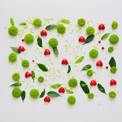 Hearts with pattern from petals of chrysanthemum flowers, ficus leaves and ripe rowan on white background. Overhead view. Flat lay.