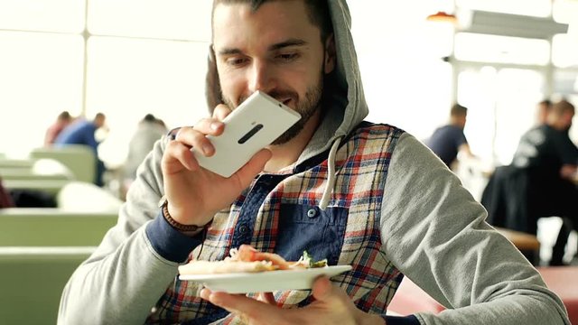 Man holding plate with slice of pizza and doing photo of this, steadycam shot
