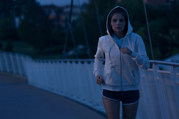 Hooded woman running in the park at night - 142562437