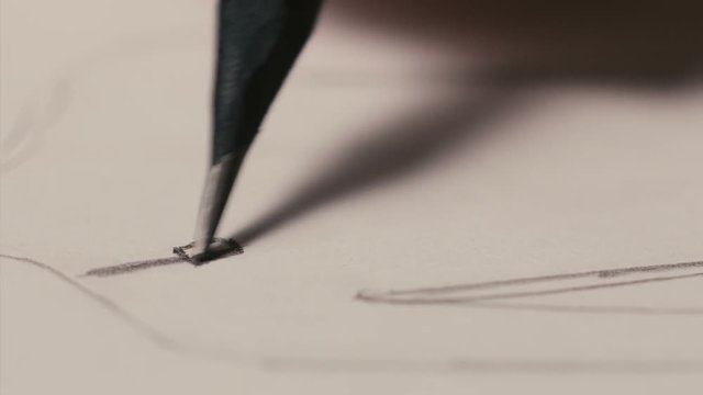 closeup of jewelry designer draws sketches with a pencil