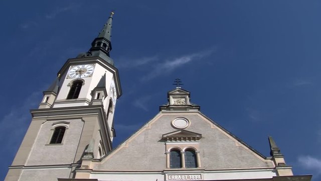 Kirchturm der Kirche Hl. Peter und Paul von Pischelsdorf am Kulm und dahinziehende Wolkenfetzen am tiefblauem Himmel (Zeitraffer)