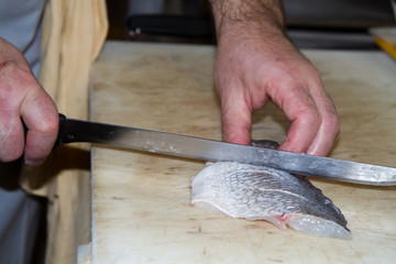 cook preparing salmon to be cooked