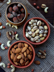 A composition from different varieties of nuts on a wooden background - almonds, cashews, peanuts, walnuts, hazelnuts, pistachios.