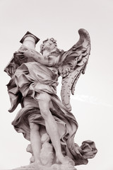 Statue on 17th Century Pont Sant Angelo Bridge by Bernini in Rome in late evening light, Italy