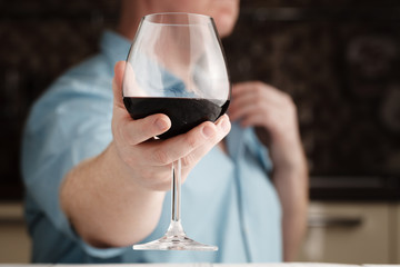 Mid section of man offering a glass of wine