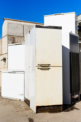 Discarded fridges and freezers at a local waste station. Here they stand in wait for transport to be recycled. Logos removed. - 142564288