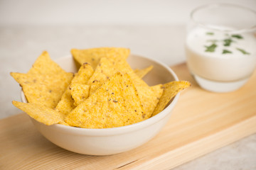 Delicious nachos with cheese on the white wooden background. Shallow depth of field.
