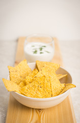 Delicious nachos with cheese on the white wooden background. Shallow depth of field.