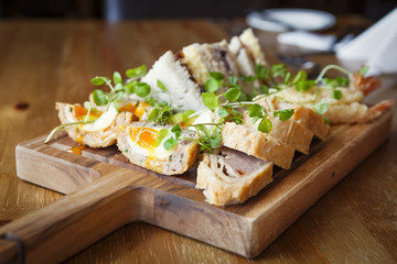  Scotch egg on platter, served on a wooden chooping board.