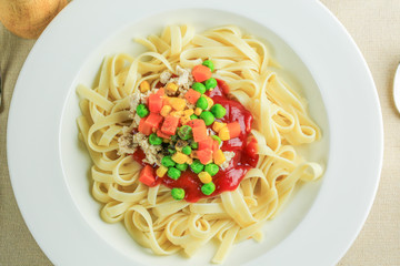 Spaghetti with topping red sauce on wooden table, still life food.