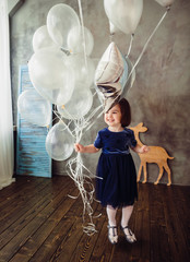 The small girl keeps ballons in the room