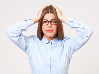 Studio portrait of upset young business woman on gray background.