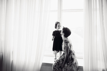 The mother with daughter sitting on the window-sill