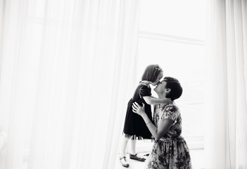 The mother with daughter sitting on the window-sill