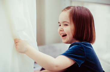 Fototapeta premium The pretty girl sits on the window-sill