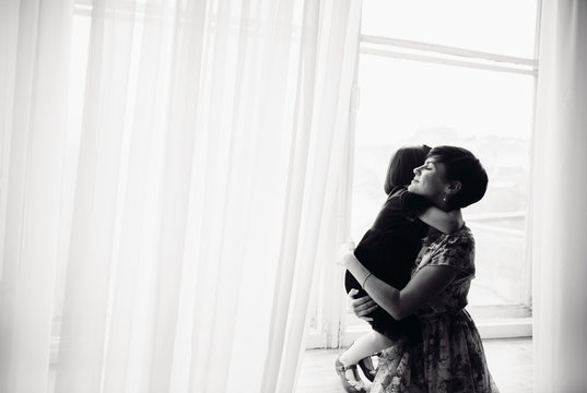 The mother with daughter sitting on the window-sill