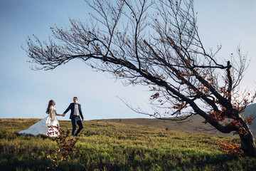 Groom leads stunning bride from spring hill