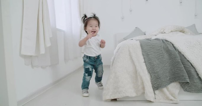 slow motion, Steadicam shot little Asian girl fun runs playing in the room