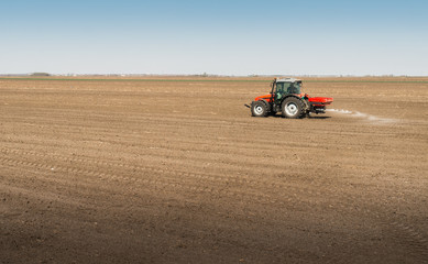 Obraz premium Tractor spreading artificial fertilizers