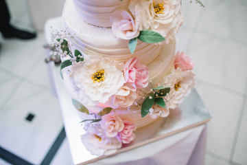 Look from above at delicious flowers on white wedding cake