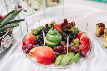 Cut fruits stand on glass plate