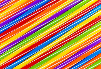 Background out of diagonally arranged vibrantly colored drinking straws forming interesting pattern.