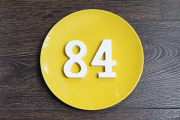 The number eighty-four on the yellow plate.