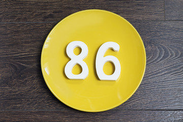 The number eighty-six on the yellow plate.
