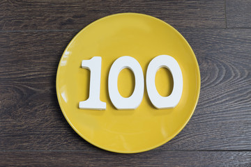 The number one hundred on the yellow plate.