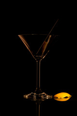 Cocktailglas mit Trinkhalm und Zitronenschale