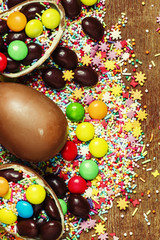 Fototapeta na wymiar Easter background with chocolate eggs and multi-colored sugar, top view