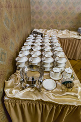 Rows of white porcelain empty cups with saucers for tea and coffee