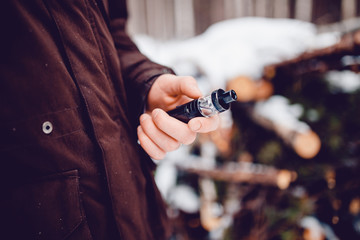 vaping man holding a mod device. cloud of vapor. Vape