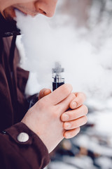 vaping man holding a mod device. cloud of vapor. Vape