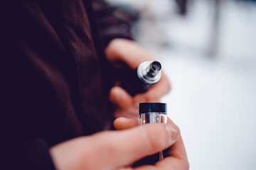 vaping man holding a mod device. cloud of vapor. Vape