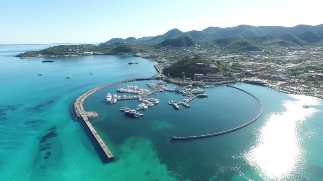 Flying over crystal blue sea and revealing boats and yatchs