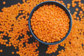 Red lentil in bowl on black background