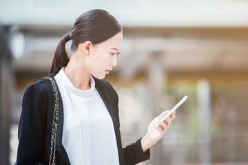 Business women looking at smart phone on her hand