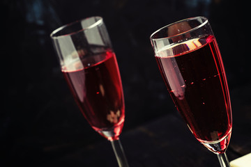 Red sparkling wine, black background, selective focus