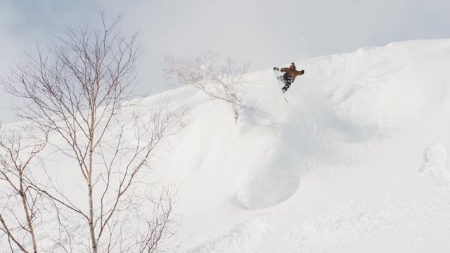 Snowboarder Backside 540 Air Natural Mountain Jump Spinning Trick Hat Flies Off
