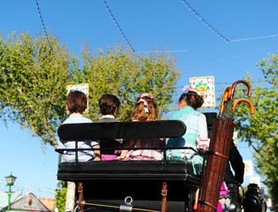 Niños y niñas en un coche de caballos, Feria en España