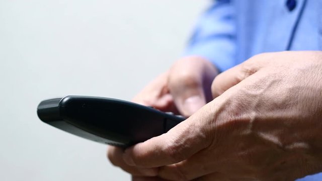 Elderly Man Hand Dialing Cordless Phone