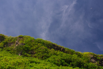 Fototapeta na wymiar View of green hill and blue sky