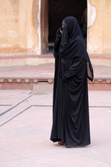 Muslim woman talking on a mobile phone in Red Fort, Agra. Uttar Pradesh, India