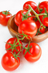 Fresh juicy red cherry tomatoes on a branch on a light background flat lay closeup