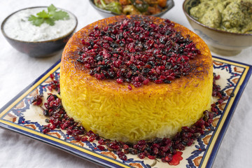 Traditional Persian Rice Pie with Curry and Joghurt as close-up on a table